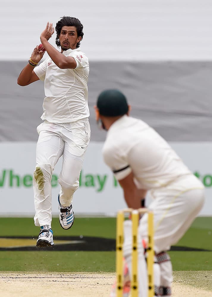 India's Ishant Sharma bowls to Australia's David Warner, right, on the fourth day of their cricket test match in Melbourne, Australia.