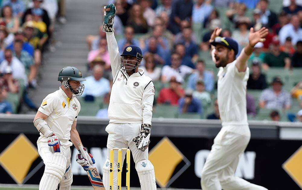 India's MS Dhoni and Virat Kohli appeal for a LBW decision on Australia's Chris Rogers on the fourth day of their cricket test match in Melbourne, Australia.