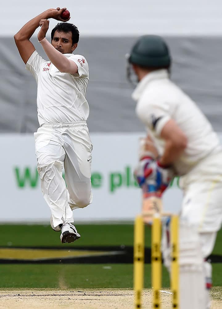 India's Mohammed Shami bowls to Australia's Chris Rogers on fourth day of their cricket test match in Melbourne, Australia.