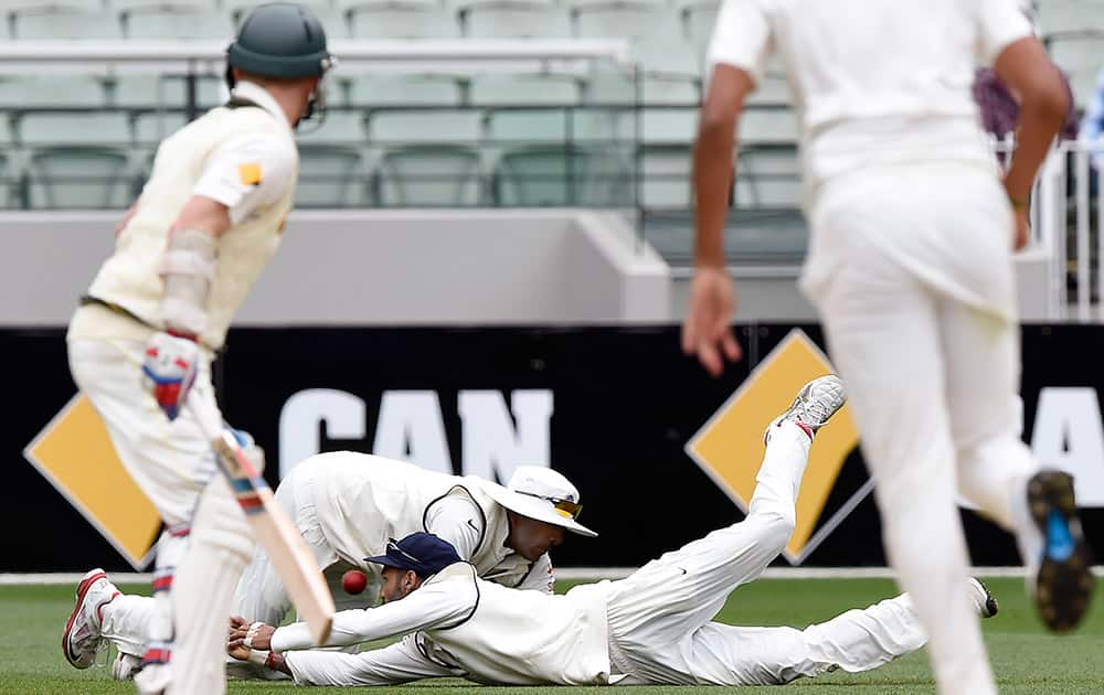 Ravichandran Ashwin and Shikhar Dhawan, both dive but miss a catch on Australian batsman Chris Rogers, on the fourth day of their cricket test match in Melbourne, Australia.