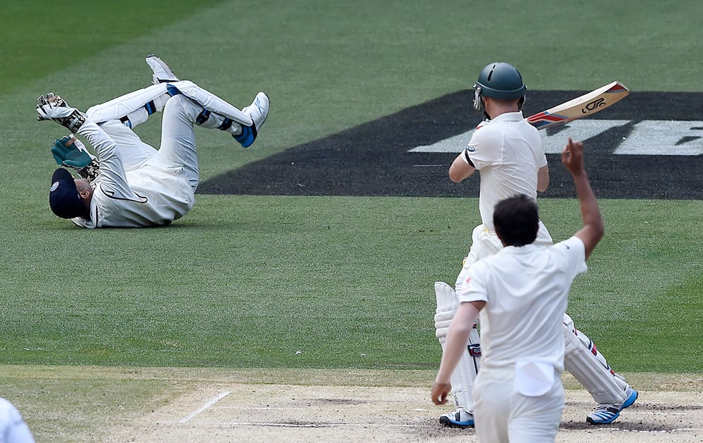 Australia's Chris Rogers, watches his shot fall short of India's MS Dhoni, off the bowling of Mohammed Shami, on the fourth day of their cricket test match in Melbourne, Australia.