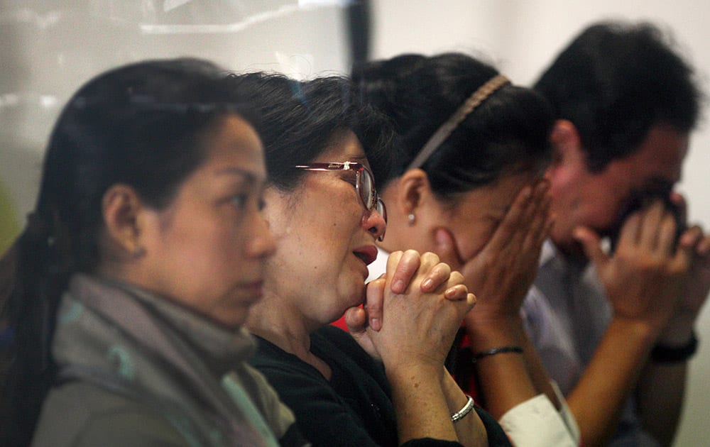 Relatives and next-of-kin of passengers on the AirAsia flight QZ8501 wait for the latest news on the search of the missing jetliner at Juanda International Airport in Surabaya, East Java, Indonesia.