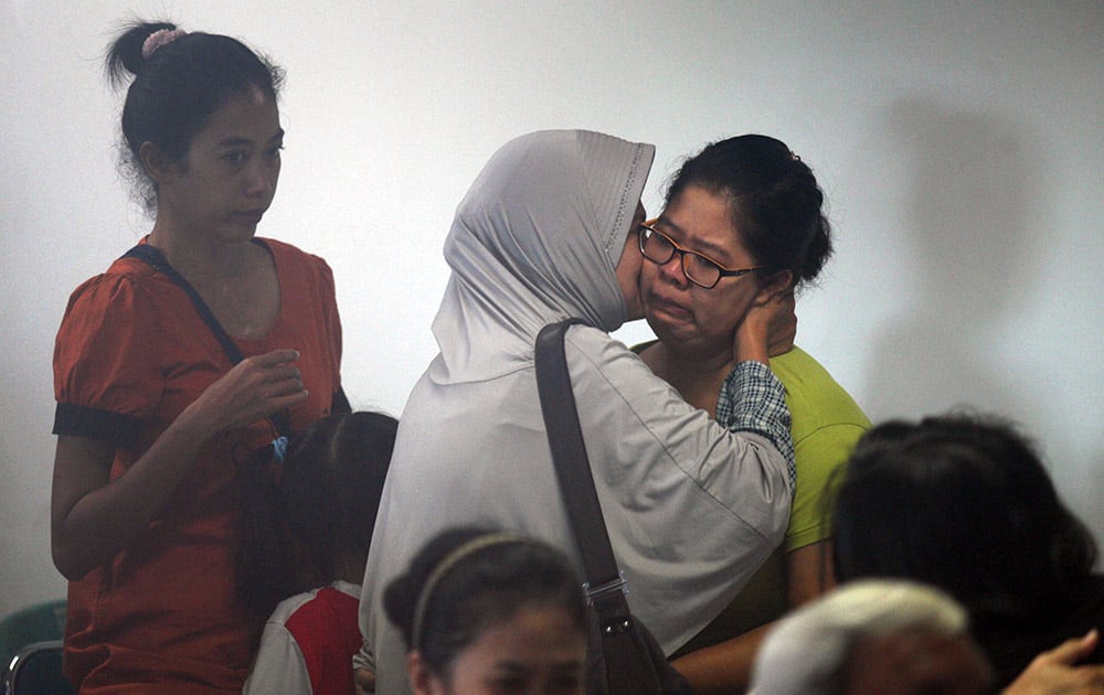 Relatives and next-of-kin of passengers on the AirAsia flight QZ8501wait, some in tears, some comforting each other, while others keep in prayer, for the latest news on the search of the missing jetliner at Juanda International Airport in Surabaya, East Java, Indonesia.