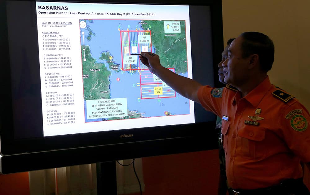 A member of Indonesian National Search and Rescue Agency (BASARNAS) shows a map of searching area on screen during a briefing prior to a search and rescue operation of the missing AirAsia flight QZ8501, at Pangkal Pinang command post, Sumatra Island, Indonesia.