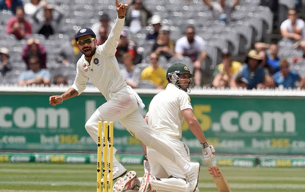 India's Virat Kohli celebrates running out Australia's Shaun Marsh on 99 runs on the final day of their cricket test match in Melbourne, Australia.