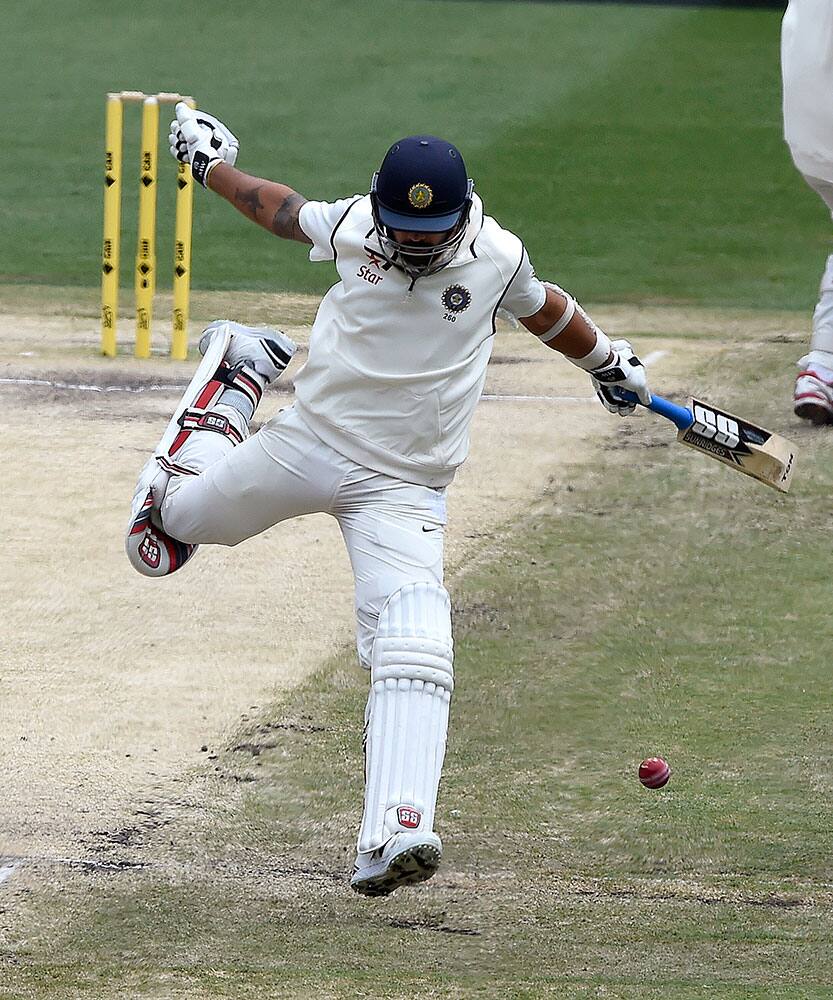 India's Murali Vijay dodges a thrown ball as he makes his ground against Australia on the final day of their cricket test match in Melbourne, Australia.