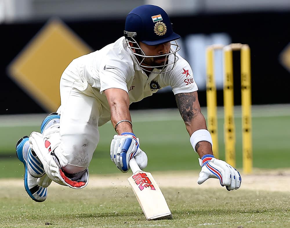 India's Virat Kohli dives to make his ground to avoid being run out against Australia on the final day of their cricket test match in Melbourne, Australia.