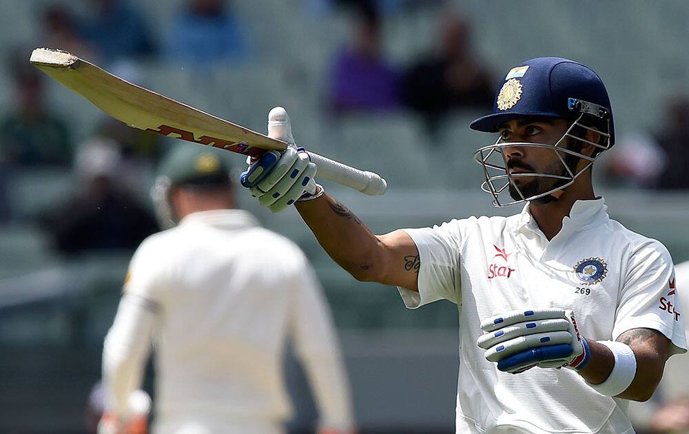 India's Virat Kohli raises his bat after making 50 runs against Australia on the final day of their cricket test match in Melbourne, Australia.