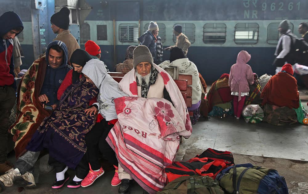 Passengers wait for a train amidst morning fog in Jammu. Cold wave conditions continue unabated in the northern region with fog enveloping most areas and affecting transport services.