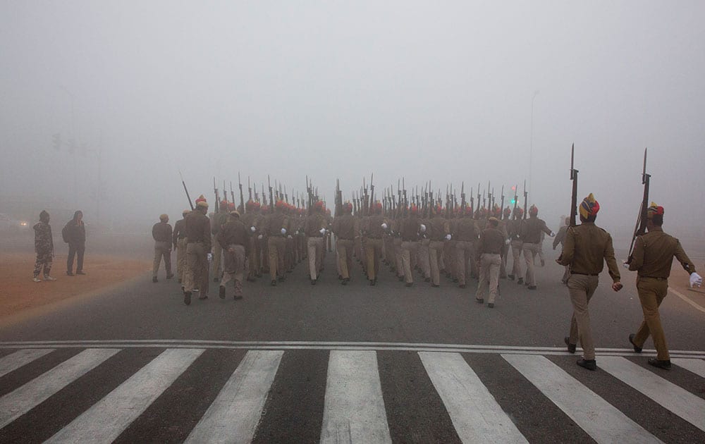 Delhi police personnel practice marching in preparation for the upcoming Republic Day parade amidst morning fog in New Delhi.