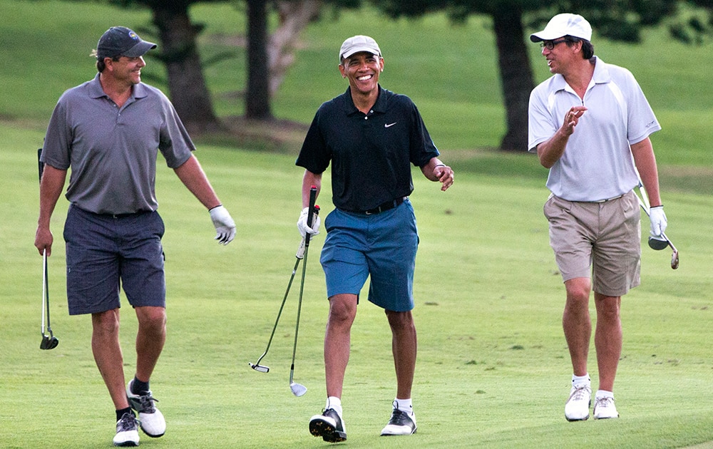 President Barack Obama smiles broadly while golfing with friends Bobby Titcomb and Mike Ramos, on the 18th hole of the Mid Pacific Country Club in Kailua, Hawaii during the Obama family vacation.