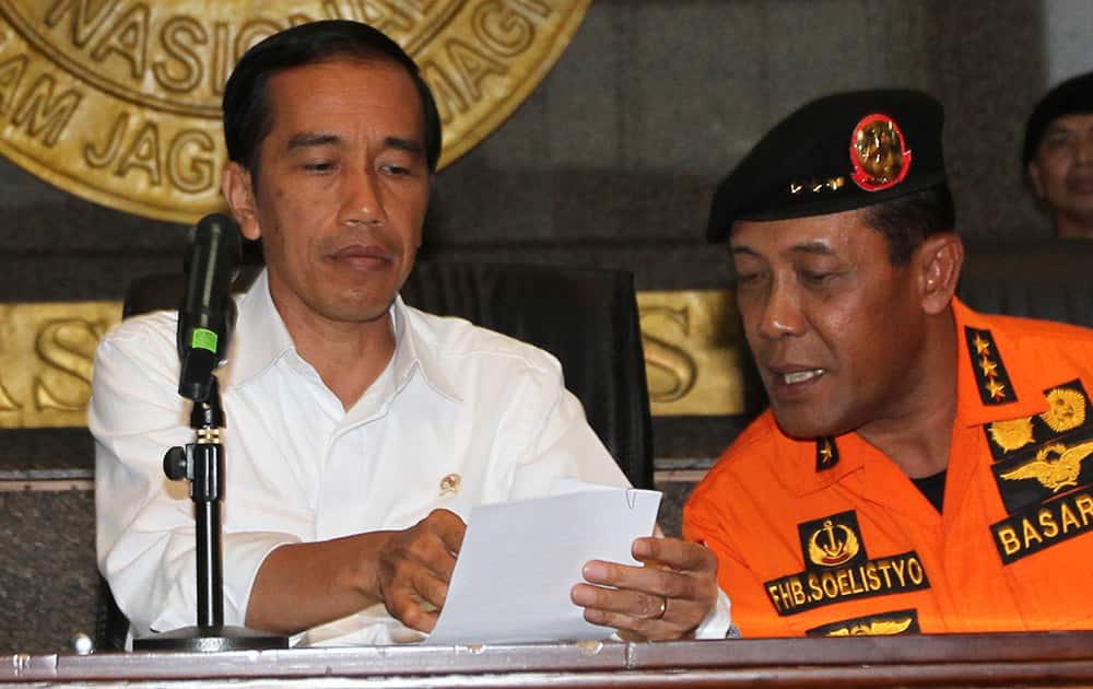 Indonesian President Joko Widodo, talks with F. Henry Bambang Sulistyo, chief of the National Search And Rescue Agency (BASARNAS) during a press conference at BASARNAS headquarters in Jakarta, Indonesia.