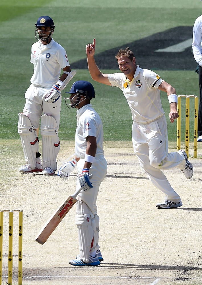 Australia's Ryan Harris, celebrates taking the wicket of India's Virat Kohli, for 54 runs on the final day of their cricket test match in Melbourne, Australia.