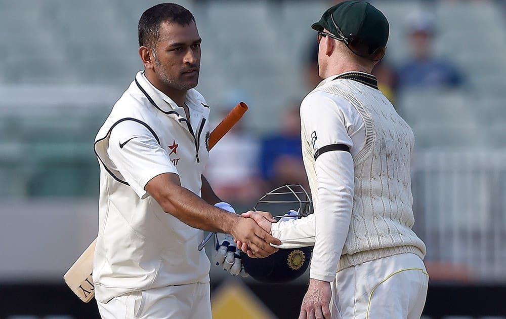 India's captain MS Dhoni, shakes hands with Australia's Chris Rogers at the end of the final day of their cricket test match in Melbourne, Australia. The match ended in a draw and Australia takes an unbeatable 2-0 lead in the series. 