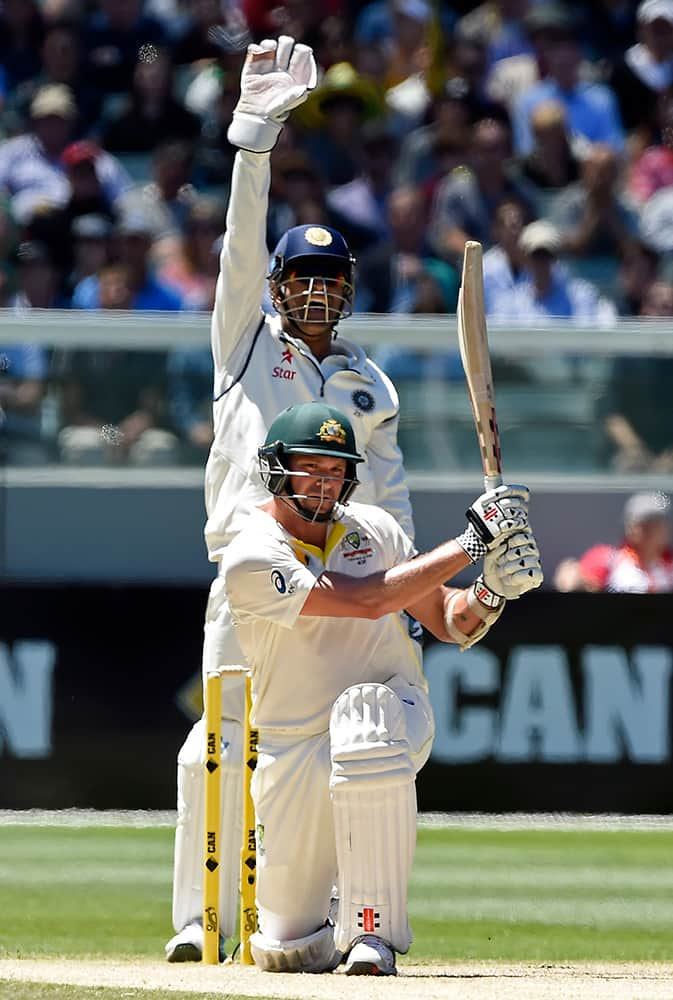 MS Dhoni appeals for, and is granted, a LBW decision on Australia's Ryan Harris, front, for 74 runs on the second day of their cricket test match in Melbourne, Australia.