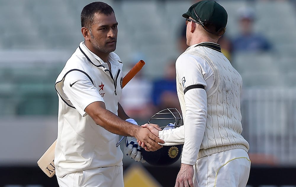 India's captain MS Dhoni, shakes hands with Australia's Chris Rogers at the end of the final day of their cricket test match in Melbourne, Australia. The match ended in a draw and Australia takes an unbeatable 2-0 lead in the series. 