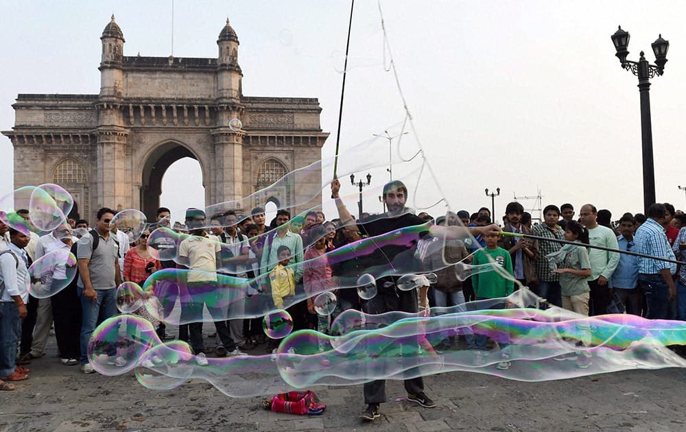 Argentine traveller Demian Zen performs a giant bubbles show at Gateway of India in Mumbai.