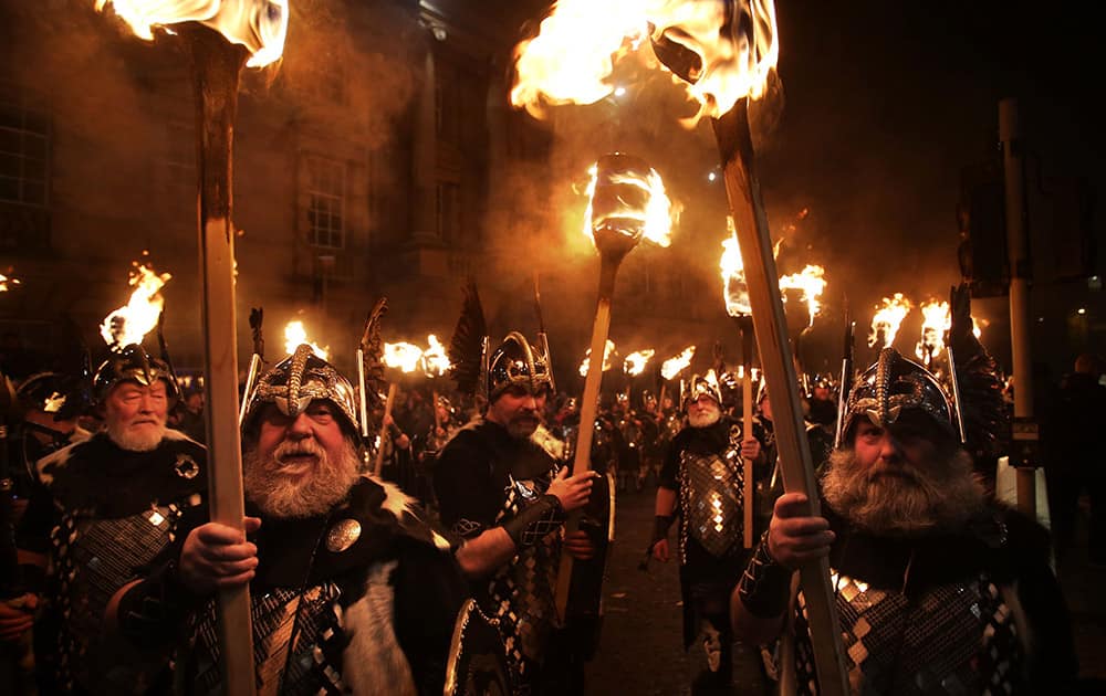 Men dressed as Vikings carry torches during the Hogmanay Torchlight Procession in Edinburgh, Scotland.