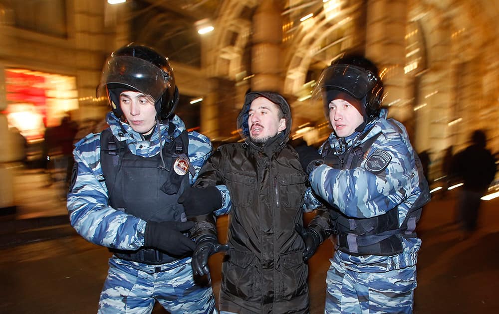 Police officers detain a protester during an unsanctioned protest in Moscow, Russia.