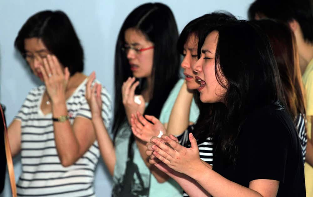 Relatives of passengers of AirAsia Flight 8501 pray at Juanda International Airport in Surabaya, East Java, Indonesia.