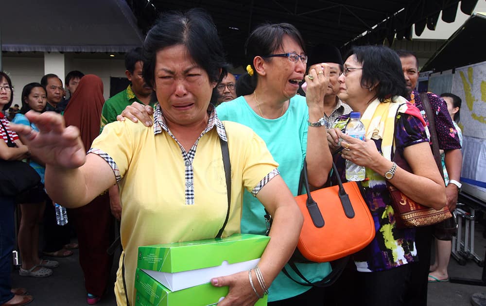 Relatives of passengers of AirAsia Flight 8501 cry after visiting the crisis center at Juanda International Airport in Surabaya, East Java, Indonesia.