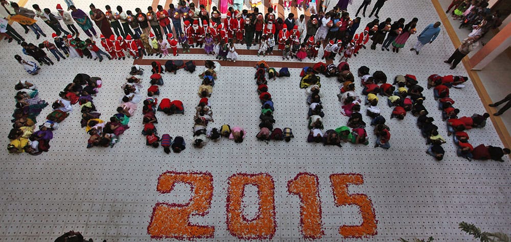 Students form numbers representing the year 2015 during a function to welcome the New Year at a school in Ahmedabad.