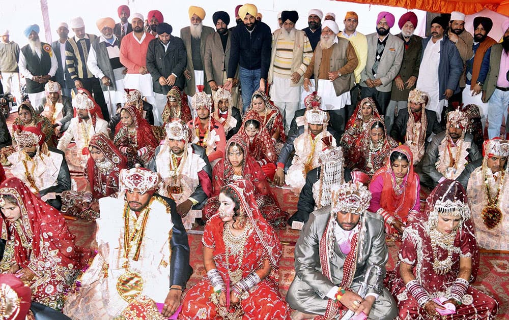 Punjab Cabinet Minister Bikram Singh Majithia blessing couples at a mass marriage in his village Majitha , near Amritsar.