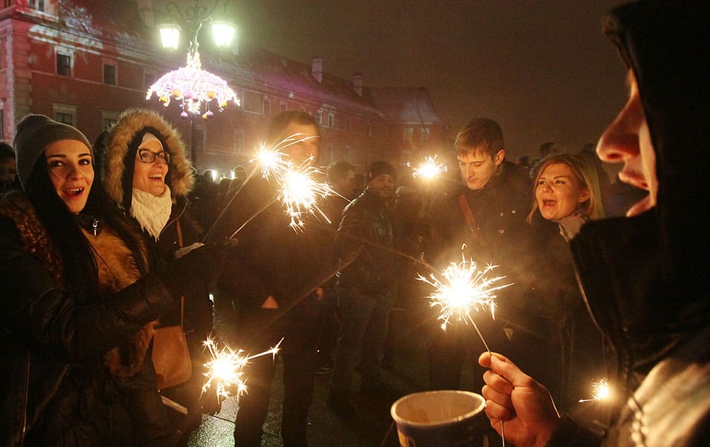 People gather to see fireworks display and celebrate the New Year at Castle Square in Warsaw, Poland.
