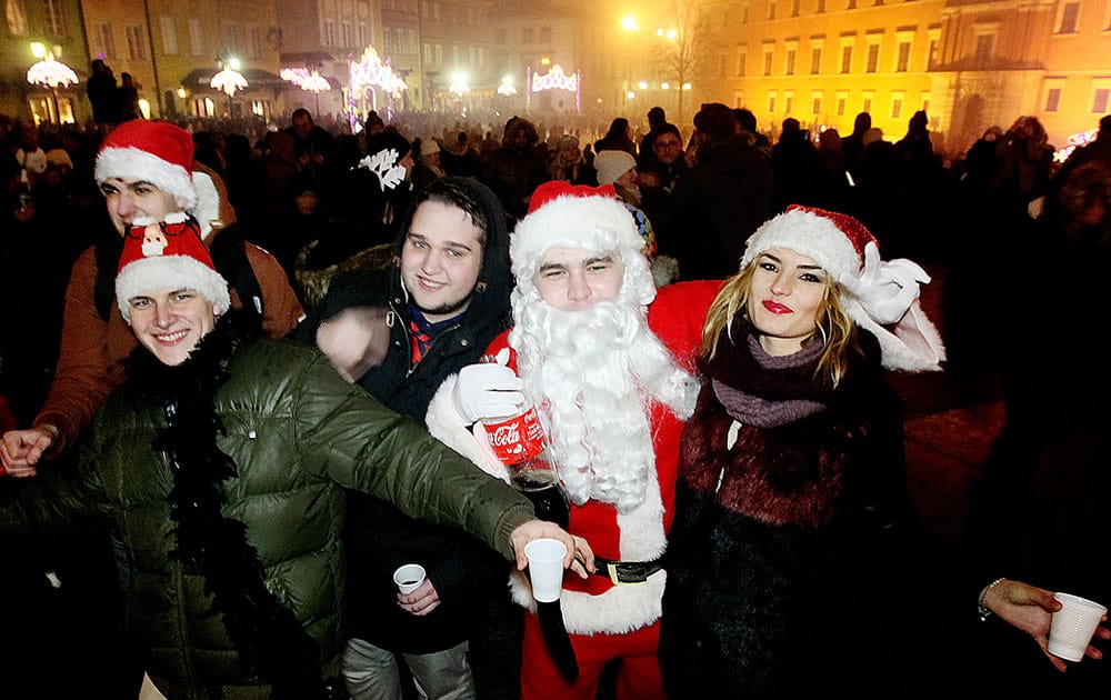 People gather to see the fireworks display and celebrate the New Year at Castle Square in Warsaw, Poland.