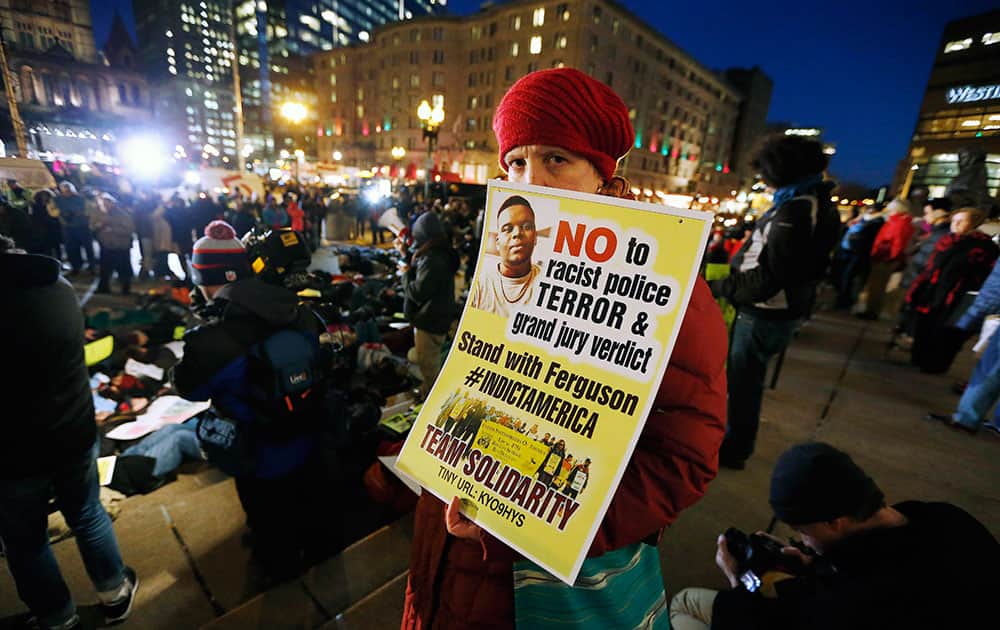 A demonstrator holds a sign in front of Boston Public Library at a protest against recent police killings of unarmed black men, during New Year's Eve celebrations in Copley Square in Boston.