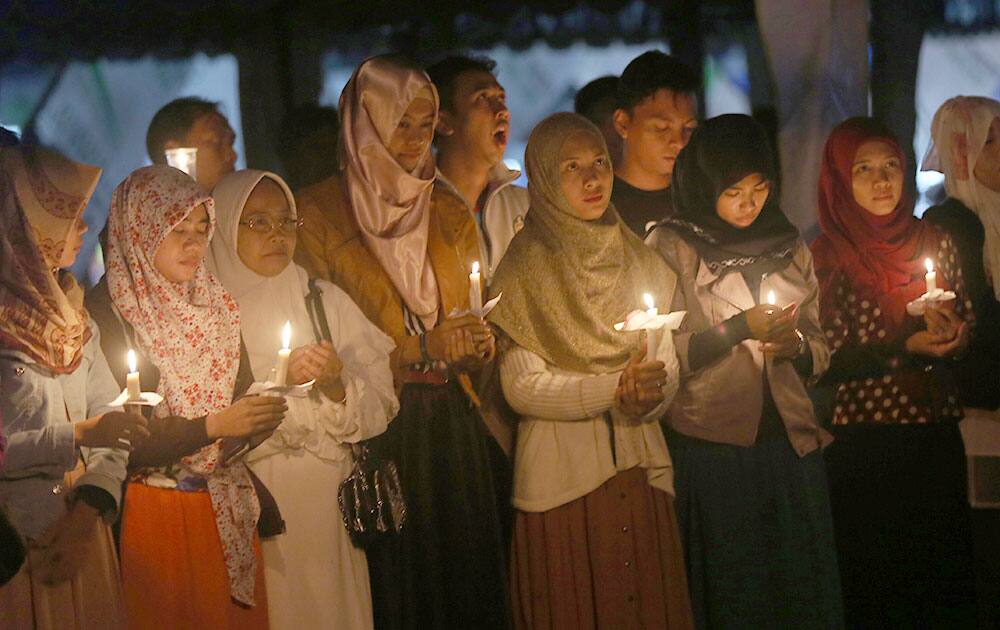 Indonesians hold candles to pray for the victims of AirAsia Flight 8501 in Pangkalan Bun, Indonesia.