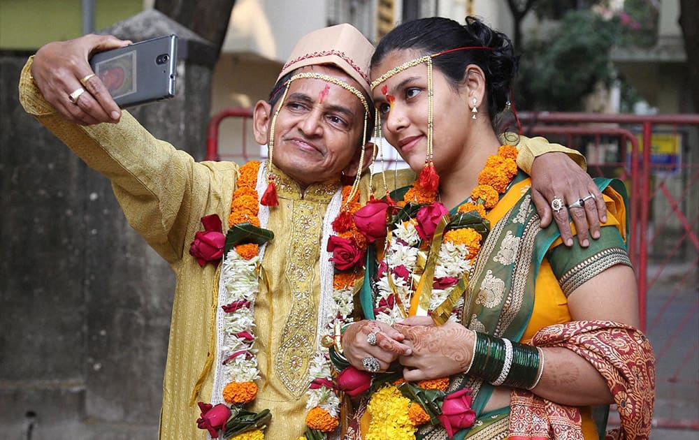 Satish Apte, 58, takes a selfie with his 20-year-old wife, Lisa, in Thane.