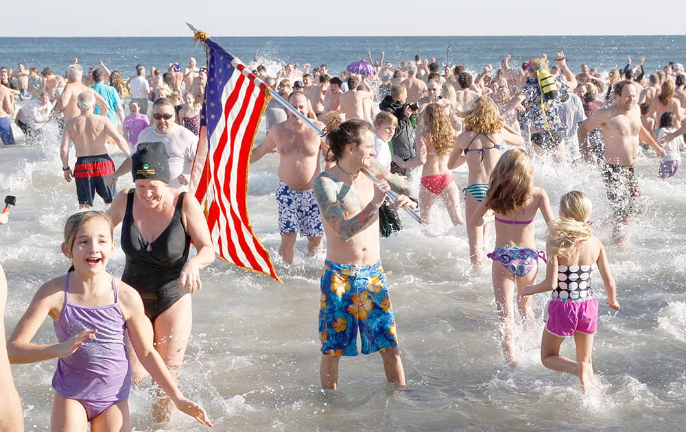 People run in and out of the cold Atlantic Ocean during the Sons of Ireland's annual New Year's Day Polar Bear Plunge on a sunny, but frigid, in Asbury Park, N.J.