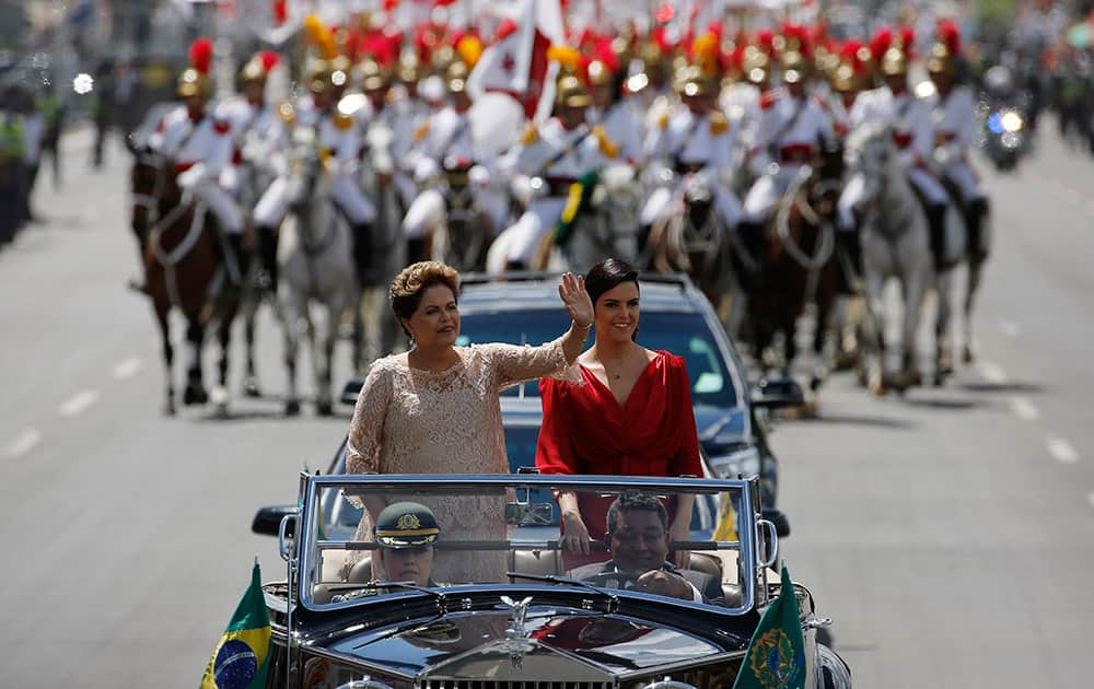 Brazil's President Dilma Rousseff, waves to the crowd, accompanied by her daughter Paula Rousseff Araujo, aboard a Rolls Royce on their way to the National Congress during her inauguration ceremony in Brasilia, Brazil.