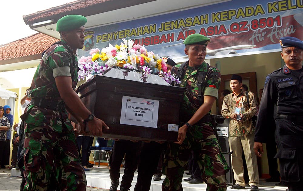 Indonesian soldiers lift a coffin containing the body of Gryson Herbert Linaksita, one of the victims of AirAsia Flight 850, during the handover to his family at the Police Hospital in Surabaya, East Java, Indonesia.