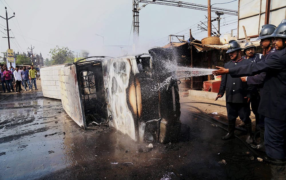 Firefighters put out fires on vehicles that were set ablaze by irate commuters at Diva Station in Mumbai. Rail traffic was disrupted following violent public protests at the Central line.