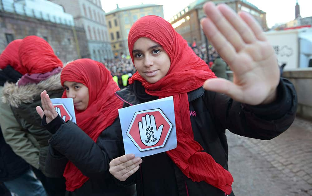 Two young girls carrying leaflets saying 'don't touch my mosque' participate in a demonstration at the parliament in Stockholm. Three mosques have suffered arson attacks in Sweden since Christmas Day.