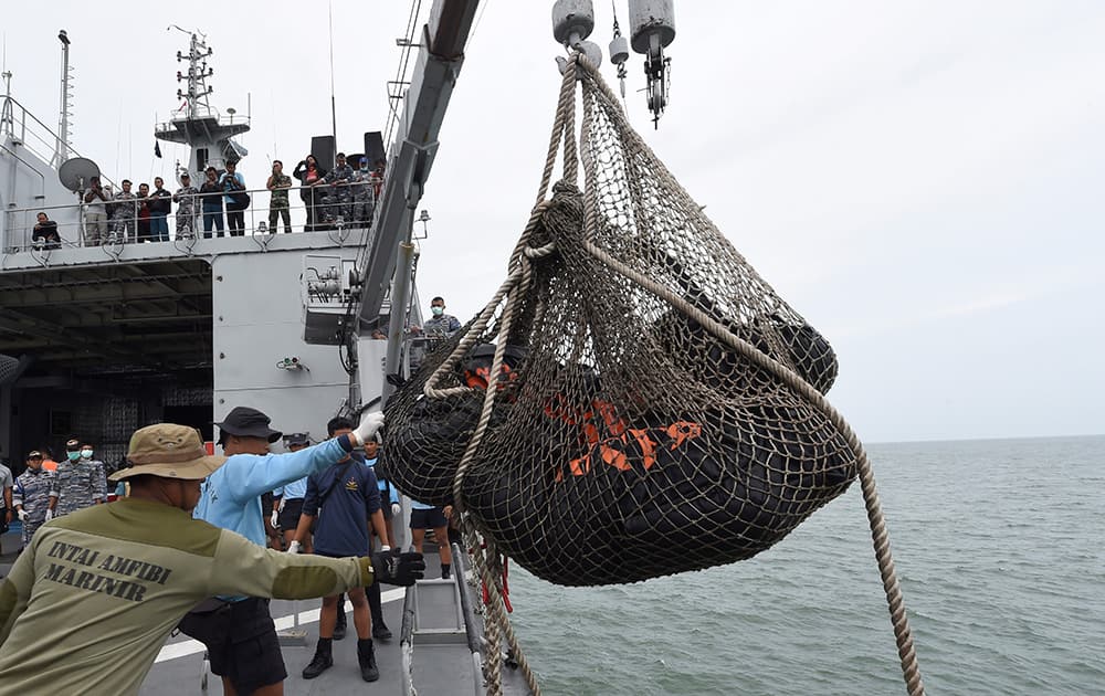 Dead bodies of victims of AirAsia Flight 8501 are lifted to Indonesian navy vessel KRI Banda Aceh at sea off the coast of Pangkalan Bun, Indonesia.