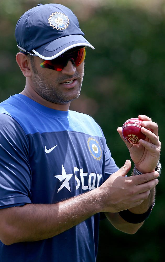 India's former cricket captain MS Dhoni prepares to bowl in the nets as his team trains before their cricket test match against Australia in Sydney, Sunday.