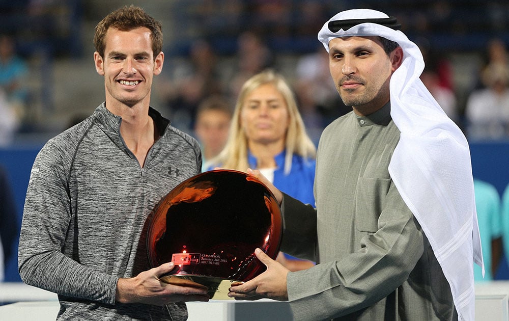 Britains Andy Murray, left, receives the winners trophy from Khaldoon Al Mubarak, CEO of Mubadala, after Novak Djokovic pulled out due to illness on the third day of the Mubadala World Tennis Championship in Abu Dhabi.