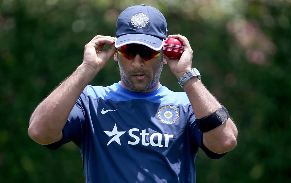 India's former cricket captain MS Dhoni adjusts his sun glasses as his team trains before their cricket test match against Australia in Sydney.