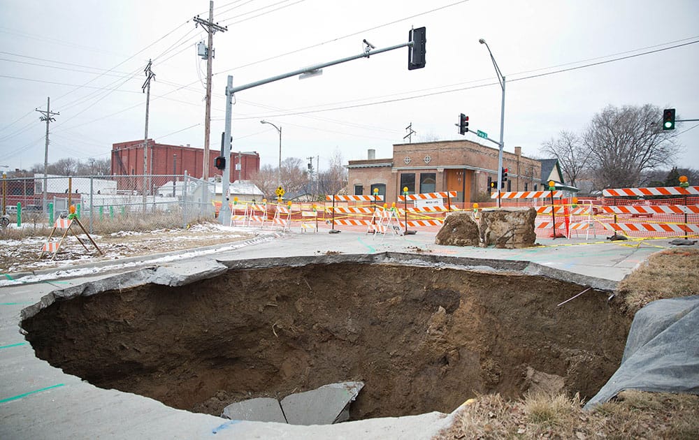 This  photo shows a sinkhole that swallowed up an entire section of a street near downtown Omaha Neb. The sinkhole is about 25 feet in diameter and about 15 deep, officials said. No injuries or property damage was reported.