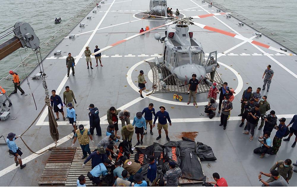 Indonesian's Navy personnel prepare the dead bodies of the passengers of AirAsia Flight 8501, on Indonesian navy vessel KRI Banda Aceh, to transfer them by helicopters at sea off the coast of Pangkalan Bun.