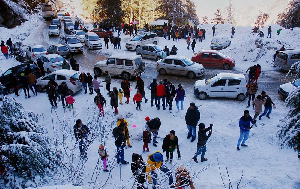 People step out of their vehicles and enjoy themselves on the snow covered ground at Kufri near Shimla.