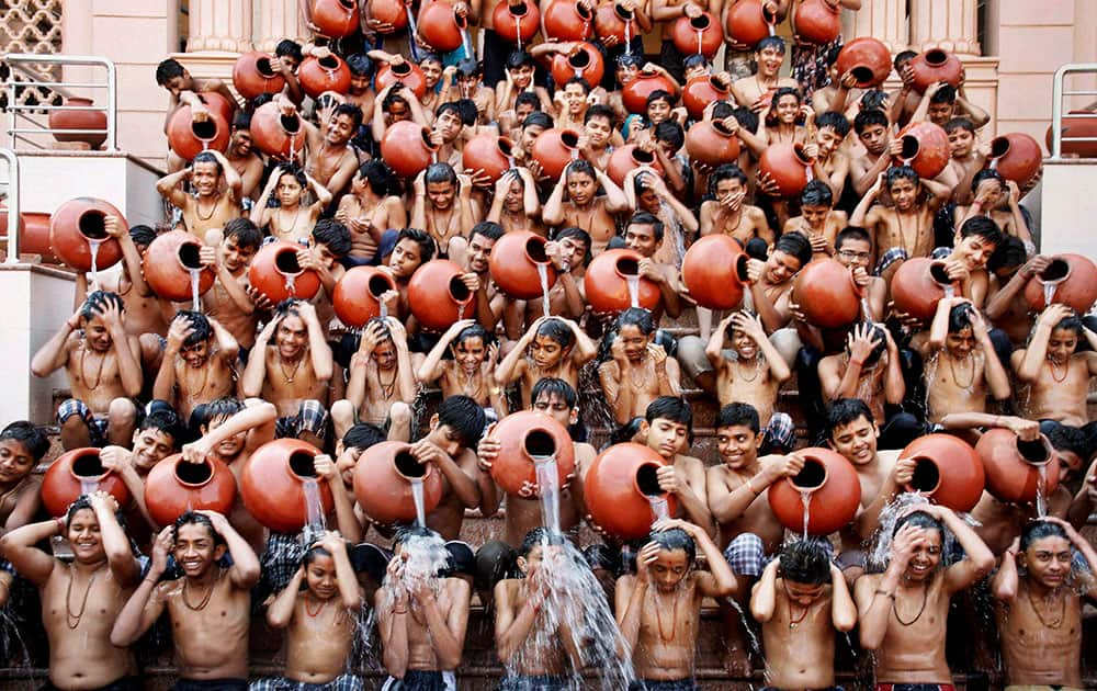 Indian students pour water on each other as part of a ritual bath on the eve of Magh Purnima in Ahmadabad.