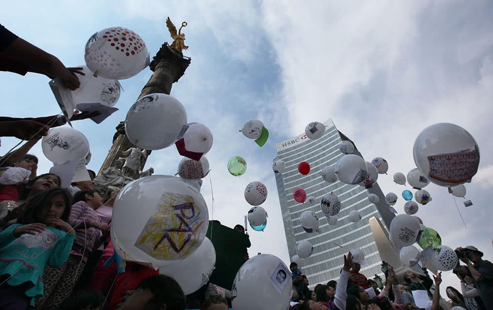 Children attach letters to balloons for the feast of the Three Kings, asking for the 43 missing colleges students, in Mexico City.