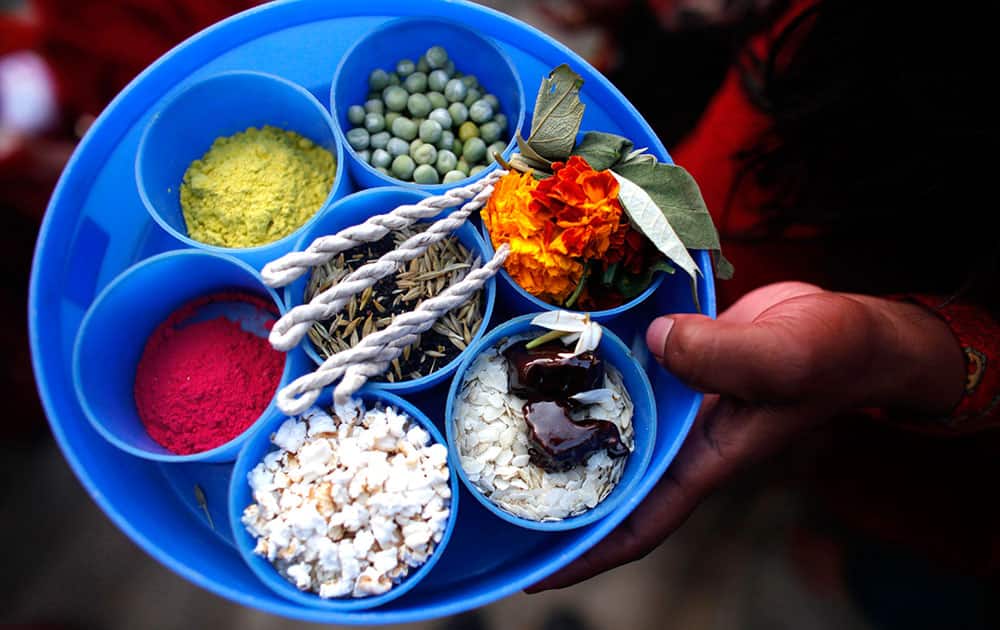 A Nepalese woman holds a plate containing a variety of items for performing a ritual during the first day of month long Swasthani Bratakatha festival in Sankhu, on the outskirts of Katmandu.