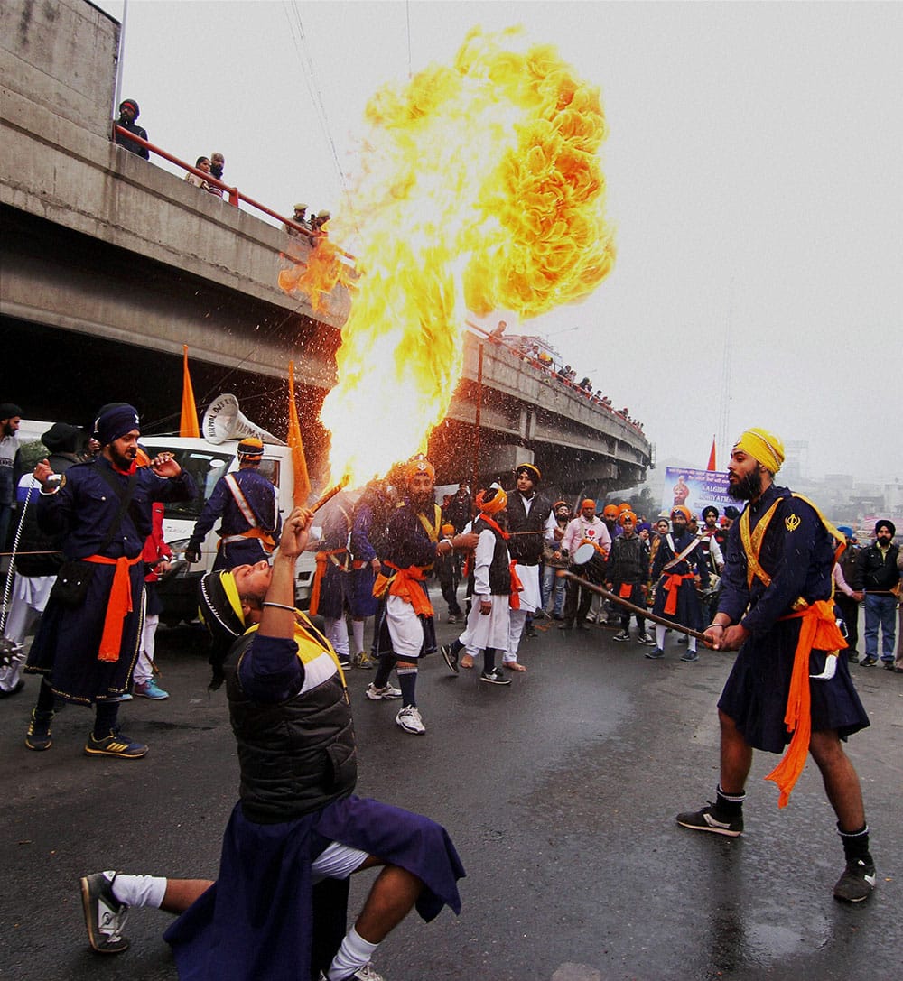 A Sikh devotee blows fire during a procession ahead of the birth anniversary of 10th Sikh Master Guru Gobind Singh in Jammu.