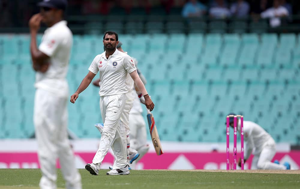 India's Mohammad Shami turns to go back to his mark after Australia's Chris Rogers was dropped in the slips by India's Lokesh Rahul, right, during their cricket test match in Sydney.