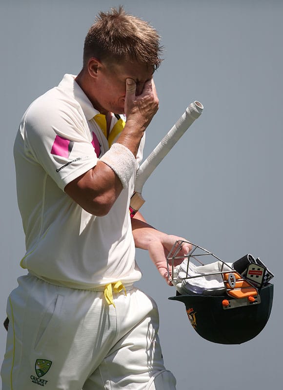 Australia's David Warner holds his head in his hand after he was caught out by India for 101 runs during their cricket test match in Sydney.